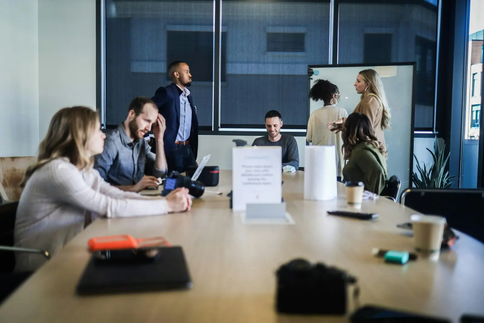 Team meeting around a long table with a presenter at a whiteboard