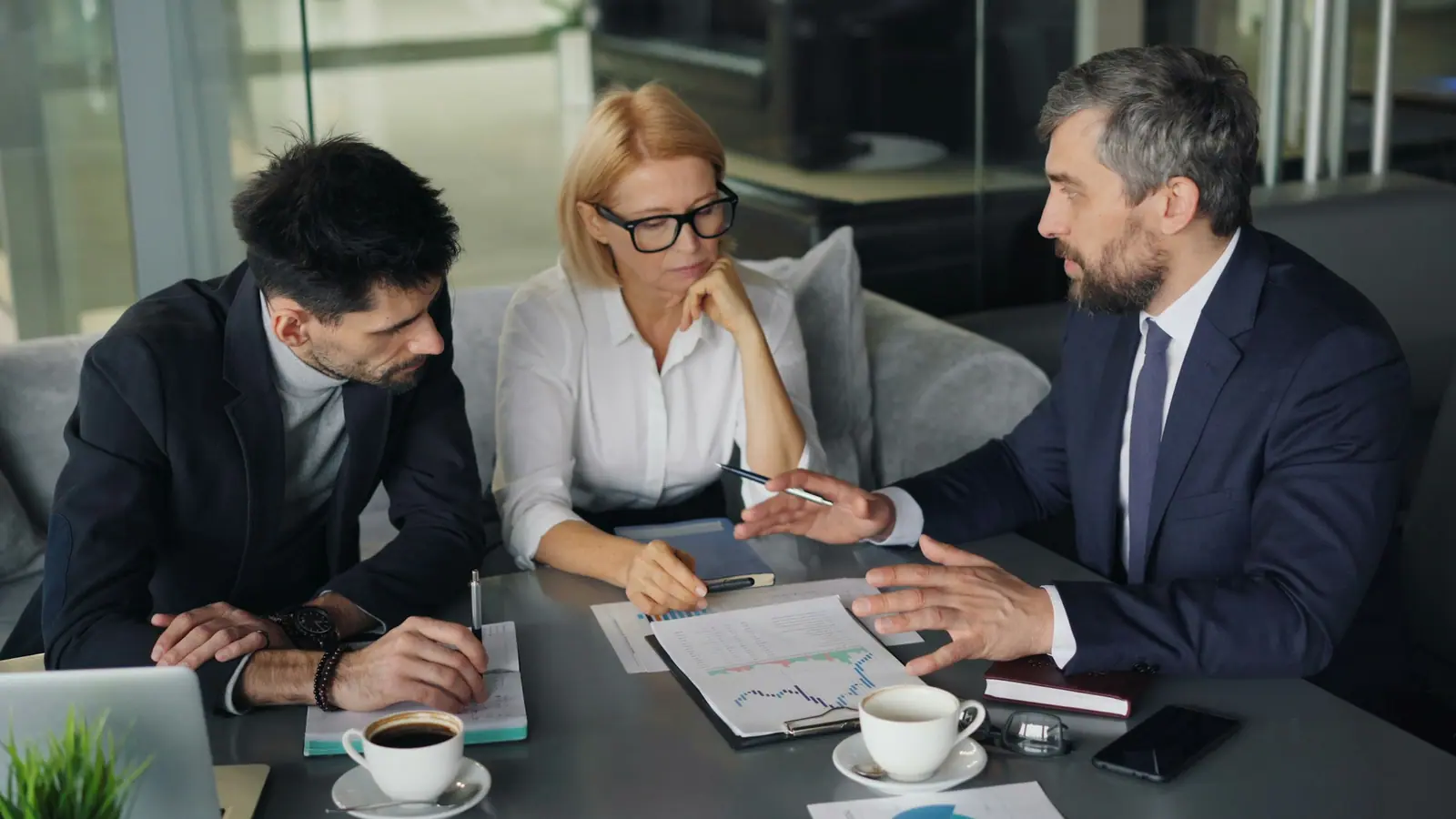 Advisors reviewing a report with a client over coffee