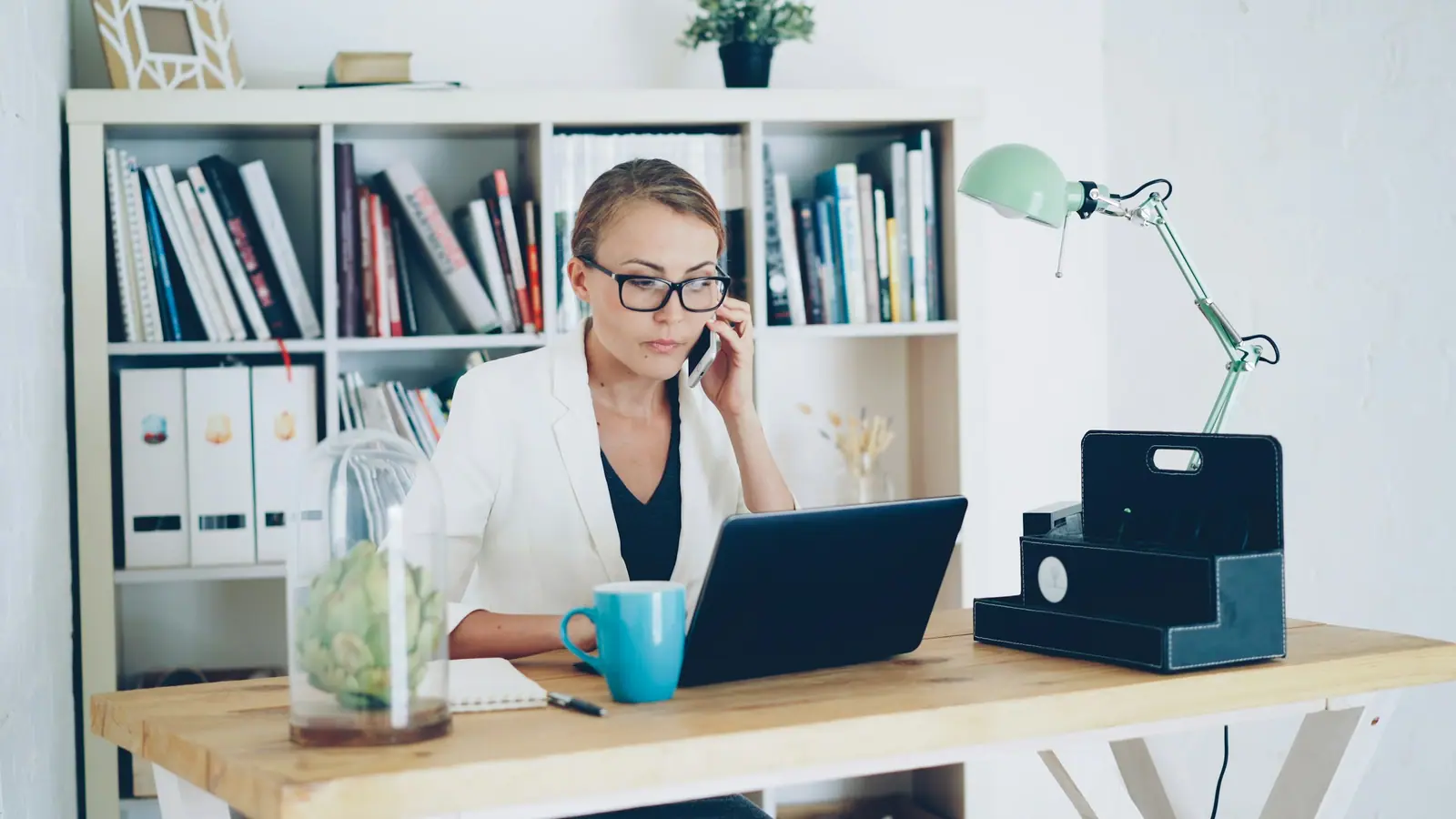 Woman on a phone call at a bright desk