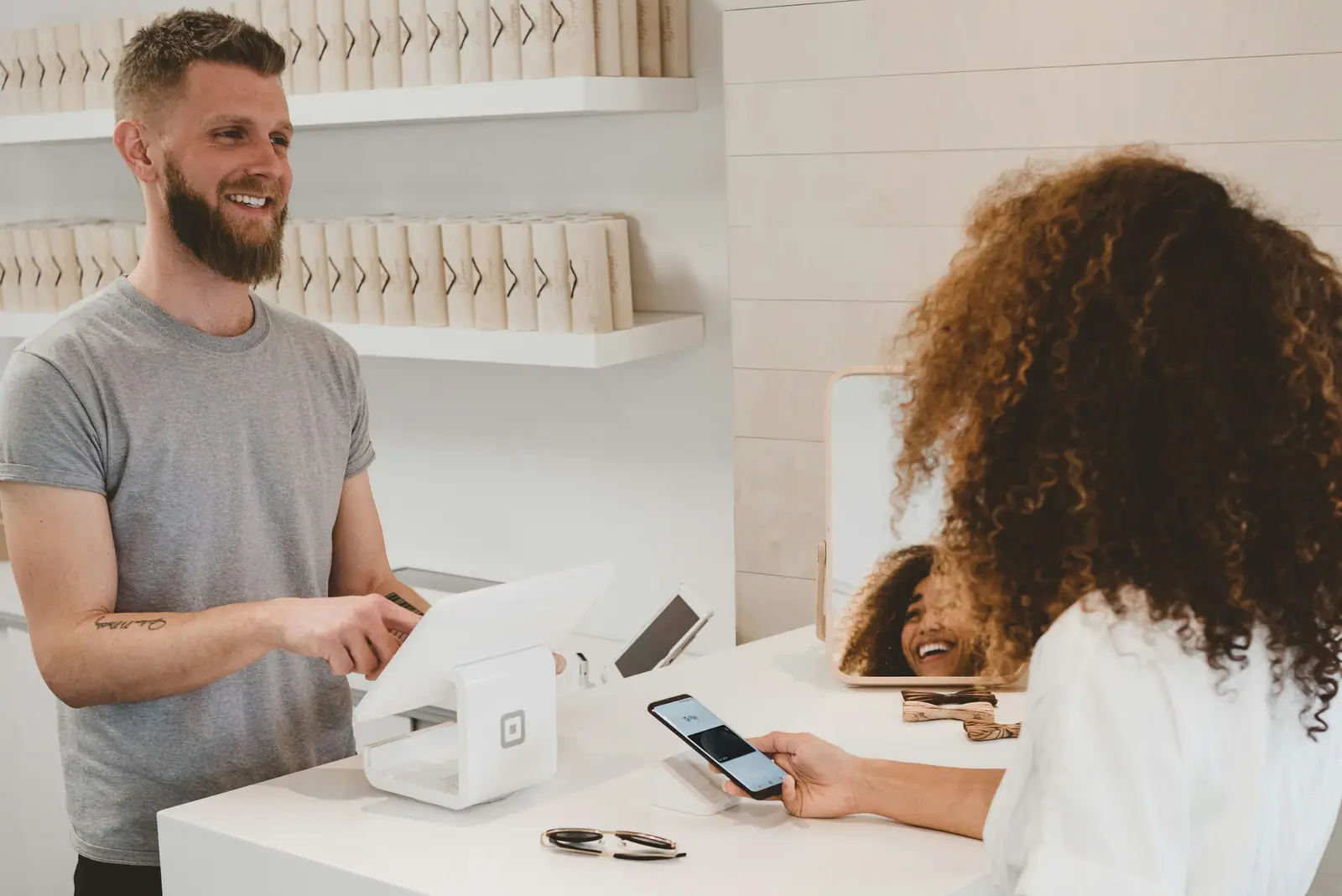 Shop owner smiling as a customer pays at the counter