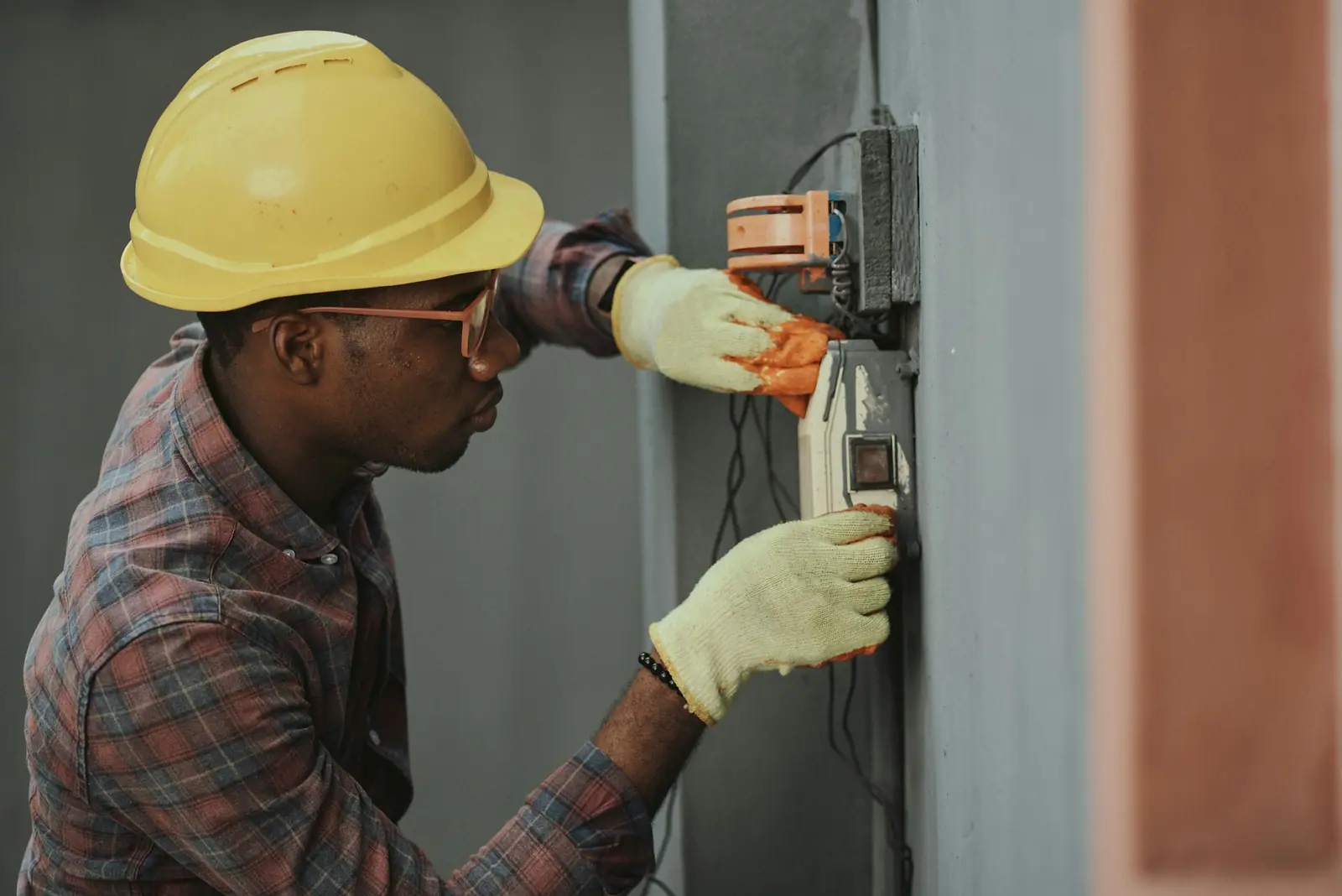 Electrician in a hard hat installing wiring